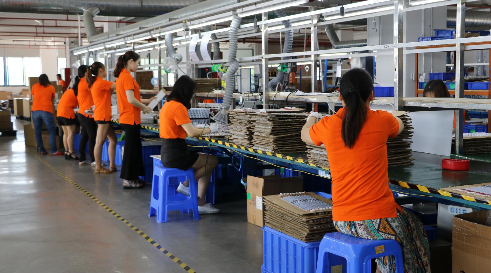 Production team assembling LED lighting modules on a factory assembly line